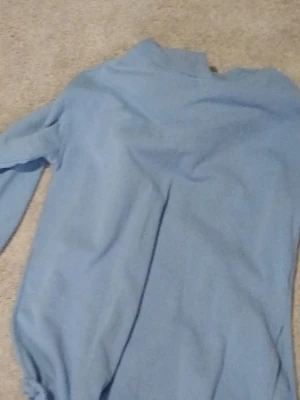 Ljusblå långärmad tröja - En enkel ljusblå tröja med lång ärm och hög hals. Tröjan har en rak och avslappnad passform och är tillverkad i ett mjukt tyg som känns bekvämt. Perfekt för en stilren och clean look.