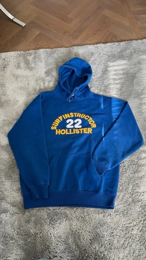 Holluster hoodie - Asfet vintage Hollister Surf Instructor hoodie från 00’ talet i bra skick. Hoodien är strl L. Riktigt fett tryck och cool unik färg. 
