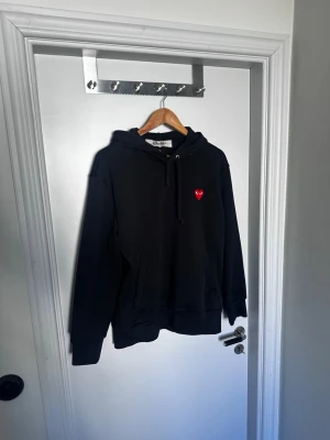 Svart hoodie Comme des Garçons Play - Svart hoodie från Comme des Garçons. Hojta till vid funderingar!