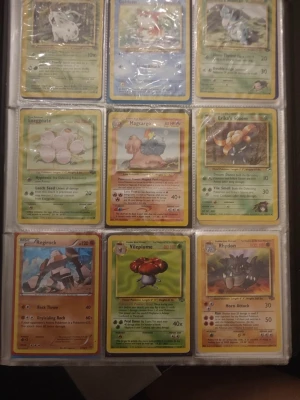 Pokémonkort samling i pärm - Stor samling Pokémonkort i plastfickor, med flera klassiska och ovanliga kort från olika generationer. Blandade färger och motiv med både gräs-, vatten-, eld- och sten-Pokémon. Perfekt för samlare eller nostalgiker som vill utöka sin kollektion.