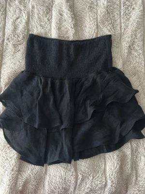 Svart volangkjol - Svart volangkjol ifrån shein som inte längre används. Man kan ha den både som en topp och som en kjol. Har ingen lapp men storlek xs men den är väldigt stretching så den skulle lätt passa S,m🧸🧸