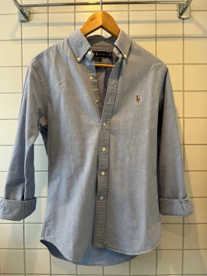 Ralph lauren skjorta  - Nu säljer jag min ljusblåa ralph lauren skjorta! Den är i storlek S och är slim fit. Säljer den för att den är för liten vilket man ser på bilderna. Användes under förra sommaren men är som nyskick. Hör av dig för fler frågor och bilder!!!