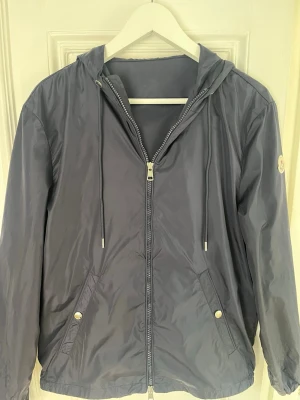 Mörkblå moncler vindjacka  - Säljer denna mörbklå moncler windbreakern i strlk 1/s. Skick 9/10 använd ett fåtal gånger, självklart äkta. Behöver pengarna snabbt därav ett lägre pris. Priset e ej hugget i sten så kom me bud