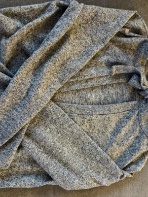 Grå kofta från 157 i storlek XS - Mysig gråmelerad kofta från 157 med lång ärm och öppen front. Perfekt att slänga på sig över en t-shirt eller topp. Tillverkad i mjukt och skönt material som känns riktigt bekvämt.