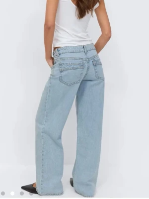 Ljusblåa wide leg jeans - Säljer ett par ljusblåa jeans med wide leg-modell och hög midja. Jeansen har klassiska fem fickor och raka, vida ben för en avslappnad och trendig look. Perfekta för dig som gillar en loose fit och vill ha en modern streetstyle.