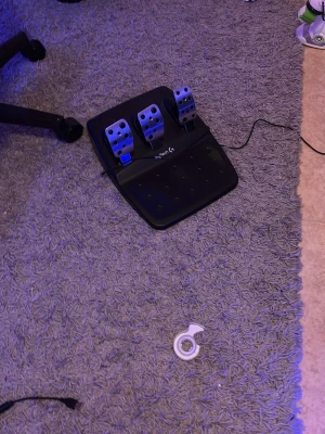 Logitech G923 - Säljer ett Logitech G pedalset för racing och simulatorer. Setet har tre metallpedaler monterade på en svart plastbas med USB-kabel för anslutning till dator eller konsol. Perfekt för dig som vill ta simracing till nästa nivå.