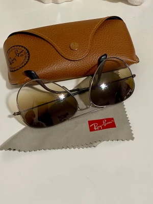 Ray-Ban aviator solglasögon silver - Klassiska Ray-Ban aviator solglasögon med silverfärgad metallbåge och mörktonade glas. Medföljer original brunt skinnfodral och putsduk. Snygg tidlös design som ger en cool vibe till alla outfits.
