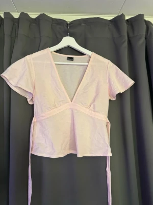 Rosa topp  - Rosa topp med knytdetalj från Ginatricot. Den är endast använd 1 gång 