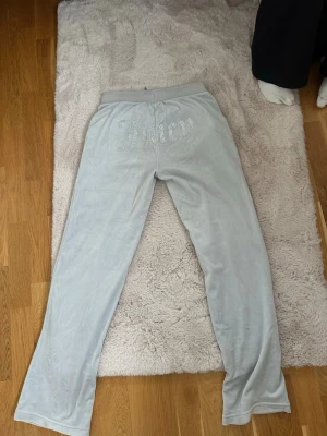 Ljusblåa velourbyxor från Juicy Couture - Säljer ett par lljus gråa mjukisbyxor från Juicy Couture i mjuk velour..