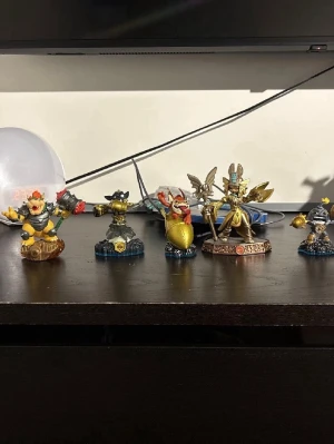 Skylanders-figurer till spel - Säljer ett gäng coola Skylanders-figurer i plast med olika färger och former. Perfekta för att använda i Skylanders-spelen på konsol. Figurerna föreställer olika karaktärer som Bowser och andra fantasyhjältar, vissa med vapen och rustningar. Samlarvänliga och snygga på hyllan!