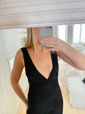 Svart långklänning med v-ringning - Säljer denna skitsnygga balklänning då den tyvärr var för kort på mig! Superskönt material i satin och jättefin🥰 Jag är 171cm och den var typ 5cm för kort om jag skulle haft klackar till tyvärr…