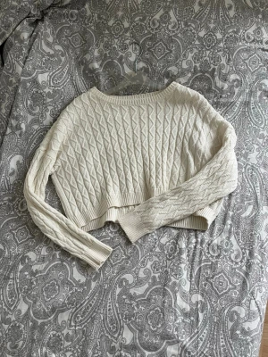 Vit kabelstickad croptröja BikBok - Säljer en vit kabelstickad croptröja från BikBok. Den är i gott skick 