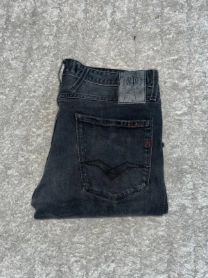 Replay Anbass jeans  - Snygga Replay Anbass Jeans i mörkgrå tvätt med kontrastmönster. Midja 42cm, 100cm. Obs storlekslapp saknas, men jag skulle bedöma till W31 L32 - men utgå alltid efter mått. JAG SKICKAR EJ FLER BILDER NÄR JAG BÄR JEANSEN! för bättre inblick i passformen rekommenderar jag att googla på modellnamnet. För storleksguide kolla måtten noggrant då jeansen alltid kan vara uppsydda heller krympta och jag ej tar emot returer :) 1,67