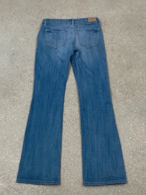 Blå bootcut jeans Abercrombie & Fitch - Super snygga jeans från abercrombie & fitch, nyskick utan några defekter, alla mått inkluderade i bilderna och nedan. 🩷 skriv om funderingar eller om ni vill diskutera pris! Är lite osäker på storleken men någonstans mellan 34-36   Midjemått: 34 cm Innerbenslängd: 76 cm Ytterbenslängd: 94