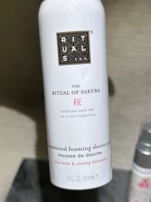 Ny! Rituals The Ritual of Sakura duschmousse - Ny! Rituals The Ritual of Sakura sensational foaming shower gel med doft av ris-mjölk och körsbärsblom. Flaskan är vit med svart och rosa text, och rymmer 50 ml. Perfekt för dig som vill ha en lyxig duschupplevelse med fräsch och blommig doft. Finns en liten buckla fram, vill nämna det och visa på bild 🫶🏻