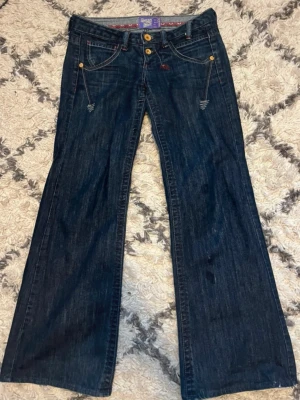 Mörkblå bootcut jeans från Replay - Säljer dessa supersnygga jeansen med väldigt låg midja. Bootcut/vida ben. Ser lite fläckade ut på höger ben, ej i verkligheten💕 Skriv privat för frågor.  Mått (cm): • midja: 38 • ytterbenslängd: 97  • innerbenslängd: 76 • benlängd nederkant: 28
