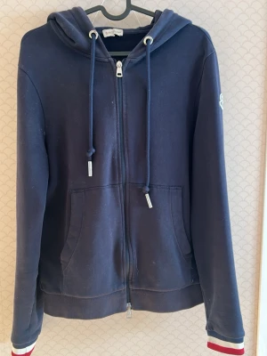 Monclear hoodie - Hejjj och välkomna till Liljestrands nu säljer vi en moncler hoodie i fint skick utan några större defekter endast lite små grejer på armbåge är de ett litet hål inget märkvärdigt och vid arm slut se bild 3 NFC Scan funkar inte antar att de är gammal modell eller liknande osäker på äktehets bevis (min brors gamla) ny pris 4000kr vårt pris endast 899kr kom med bud.MVH LILJESTRAND