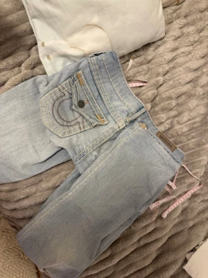 Ljusblå True Religion jeans - Säljer ett par väldigt gulliga true religens. Köpta på depart of mental som är använda en enda gång.                   Midjemått: 38X2.                                                                          Inbenslängd: 74 