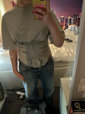 Ljusgrå tshirt med korsettdetalj - Knäppen där fram, ljusgrå 