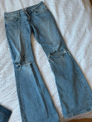 Ljusblå bootcut jeans med slitningar - Säljer ett par ljusblå bootcut jeans från 157 med snygga slitningar över knäna. Skriv för bild med dem på! ❣️