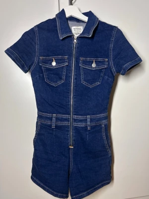 Jeans byxdress / jeans jumpsuit pull&bear - Kortbent jeans byxdress från pull&bear i storlek s. Passar även xs. Superfint skick, knappt använd. Köp sker via köp nu, jag postar inom 24h. Kvar tills markerad såld