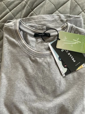 Grå t-shirt från Pelle P i bambu, nyskick - Snygg grå t-shirt från Pelle P i mjukt bambumaterial. Klassisk rund halsringning och korta ärmar. Enkel och stilren design som passar till allt. Perfekt för dig som gillar bekväma och hållbara plagg.