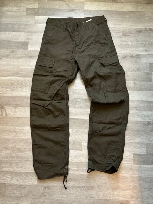 Mörkbruna cargobyxor från Carhartt - Säljer ett par mörkgröna cargobyxor från Carhartt har använt dom ett fåtal gånger och säljer dom för jag inte använder dom längre. Vid fler frågor kontakta mig 