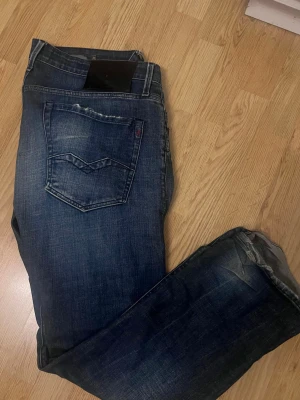 Mörkblå replay waitom - Snygga mörkblå jeans med klassisk femficksdesign och slitningar för en cool look. Jeansen har ett litet hål på bild 3. Jeansen är extrrmt sköna eftersom de har stretch och har en rak passform. Med storleken 36/34