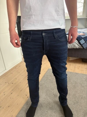 Jeans - Mörkblå tvätt med en clean och stilren look som alltid känns rätt. Smalare passform med stretch gör att de sitter snyggt utan att begränsa rörelsen. Perfekta både till vardag och när du vill vara lite mer uppklädd.