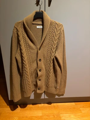 Cardigan från Jack & Jones - Hej! Säljer min brun/beigea cardigan från Jack & Jones. Storlek M och sitter fint på mig(193/74kg) hör av dig om du undrar något!