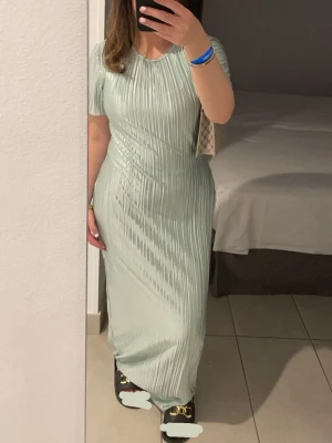 Elegant mintgrön maxi-klänning i stretchigt material - Mintgröna långklänning i mjukt, stretchigt material 💚 Använd 1 gång, i mycket bra skick – inga fläckar eller skador. Sitter snyggt på kroppen och är både bekväm och elegant. Perfekt till fest, bröllop, student, middag eller sommarkvällar ✨