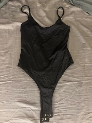 Svart body från Stradivarius XS - Säljer en svart body från Stradivarius i storlek XS. Bodyn har smala axelband, rundad urringning. Den är endast testad och lappen sitter kvar.