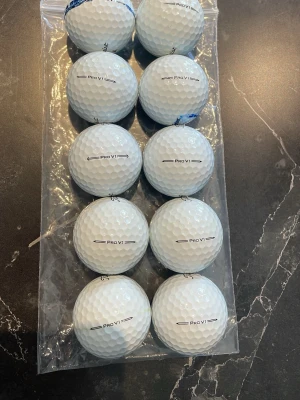 Titleist Pro V1 golfbollar 10-pack - Säljer ett 10-pack vita Titleist Pro V1 golfbollar. Perfekta för dig som vill ha riktigt bra prestanda på golfbanan. Bollarna är begagnade och kommer därför lite färg och sponsorer på bollarna. Inget är fel på bollarna bara att dem är använda.