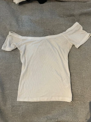 Offshoulder ribbad topp från Gina Tricot - Superfin offshoulder topp från Gina Tricot. Toppen är ribbad och har korta ärmar, perfekt för en trendig och avslappnad look. Snygg att styla med både jeans och kjol.