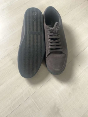 Tiger Of  Sweden bruna låga sneakers i mocka - Snygga bruna sneakers i mocka med klassisk låg profil och svarta gummisulor. Skorna har matchande bruna skosnören och enkel design som passar till det mesta. Perfekta för dig som gillar stilrena och tidlösa sneakers.