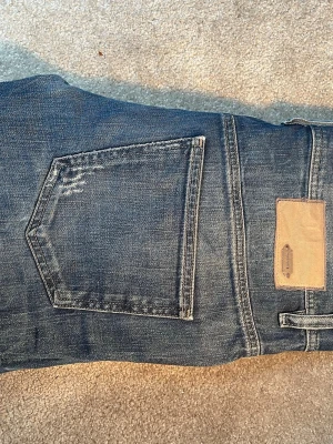 Blå jeans från Diesel  - Säljer ett par klassiska blå jeans från Diesel Industry med snygga slitningar och detaljerade sömmar. Jeansen har fem fickor. Kolla in mina andra annonser!🥰
