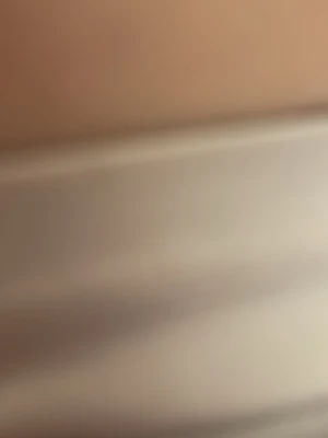 Okänd vara i beige och vitt - Bilden visar suddiga färgfält i beige och vitt. Det går inte att avgöra exakt vad varan är utifrån bilden.