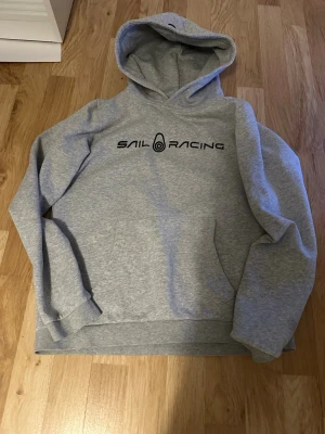 Grå hoodie från Sail Racing - Behöver pengar, sparsamt använd otroligt skönt material. St 170 nypris är runt 700-800