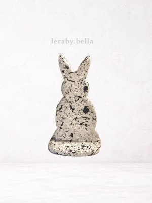 Dekorativ påskhare i lera - Unik dekoration i form av en påskhare, tillverkad i vit lera med svarta stänk och fläckar. Perfekt som prydnad till hemmet eller som påskdekoration. Stilren och modern design som passar i de flesta inredningar.