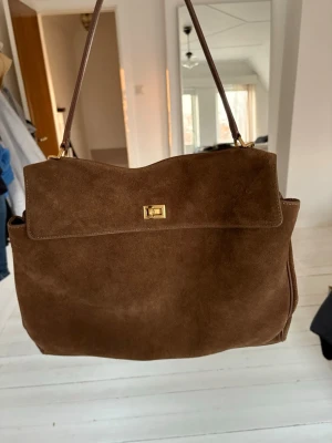 Brun mocka handväska  - Säljer väska i äkta mocka, helt nyköpt och knappt använd. Perfekt storlek utan några skavanker. Ny pris på 1500kr 