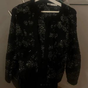 Svart glittrig kofta från Zara - Snygg svart kofta från zara me silver detaljer! Storlek S