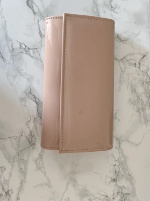 Smutsrosa kuvertväska, Nytt skick - Säljer denna snygga kuvertväska i glansigt smutsrosa🎀 Väskan bärs aningen med en guldig kedja som gör att ta av och sätta på eller så kan man hålla i själva väskan! Den är endast använd två gånger och därför i nytt fint skick💕 väskan är perfekt för festligare tillfällen och bal