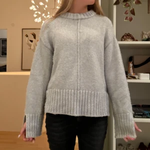 Stickad tröja  - Mysig gråblå stickad tröja med slits på sidorna och armarna. Säljer för att den inte kommer till användning 