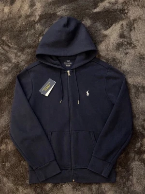 Polo Ralph lauren tröja - Super fint skick utan defekter eller liknande. Marinblå storlek S med tags och kvitto kvar. Nypris 2250kr mitt pris endast 899kr, hör av er vid frågor. Mvh Luxery closet😊🙌