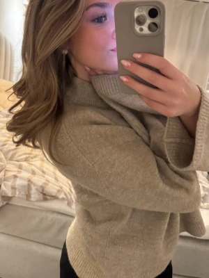 Beige stickad tröja  - En stilren beige stickad tröja. Tröjan har ribbstickade muddar vid ärmslut och nederkant, vilket ger en snygg och avslappnad look. Perfekt att matcha med jeans eller leggings för en trendig outfit.💓💓😙😙 Har även lite alpacka i sig