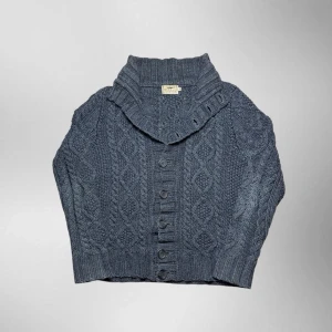 Vintage Burberry ull kabelstickad button up cardigan - herr strl M - Säljer en vintage Burberry kabelstickad button up cardigan i mörkgrå färg i storlek M. Tjockt och varmt premium material i ull.  👕 Märke: Burberry 📏 Storlek: M 🎨 Färg: Mörkgrå 🧵 Material: 52% ull, 48% polyamid 📐 Mått: 68 cm lång, 57 cm bred 📌 Skick: Mycket bra skick (se bilder)  💬 Hör av dig vid frågor 💰 Pris kan diskuteras vid snabb affär 📦 Skickas inom 24 timmar