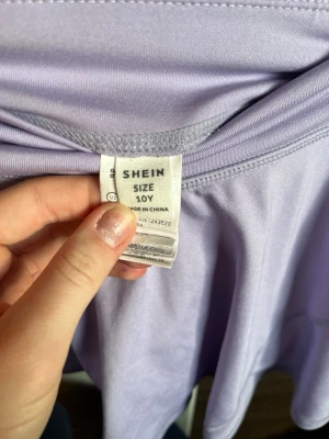 Ljuslila träningskjol från SHEIN - Supersöt ljuslila kortkjol från SHEIN med bred resår i midjan. Kjolen har en lätt utsvängd form och är gjord i mjukt och stretchigt material, perfekt för träning.