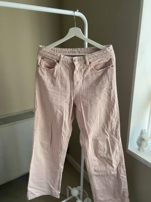 Ljusrosa jeans från Stradivarius - Säljer ett par ljusrosa jeans från Stradivarius med klassisk femficksmodell och raka ben. Jeansen har bälteshällor, knappgylf och är tillverkade i ett mjukt bomullsmaterial. Perfekta för dig som vill addera lite färg till din outfit!