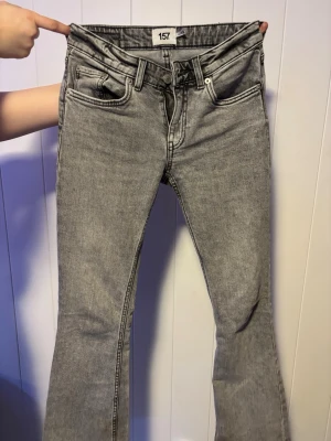 Grå bootcut jeans från 157 - Säljer ett par grå bootcut jeans från 157 med klassisk femficksdesign och dragkedjegylf. Jeansen har en snygg tvättad look och raka ben som går ut lite nedtill. Perfekta för dig som gillar en avslappnad men trendig stil. Pris kan diskuteras!