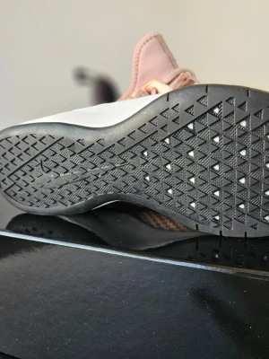 Nike Air Max Bella TR 2 träningsskor  - Snygga Nike Air Max sneakers i rosa med vävd mesh-överdel och vita detaljer. Skon har en synlig Air Max-enhet i hälen, svart yttersula med mönster för bra grepp och svart hälflik. Perfekt för dig som gillar sportig och modern stil.